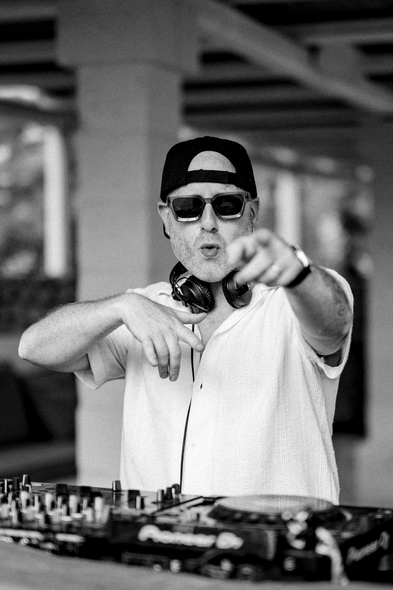 Biblical Beats pointing from behind the decks, black and white