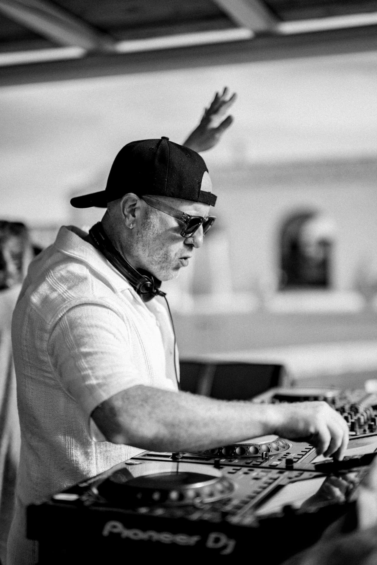 Biblical Beats mixing on Pioneer decks, hand raised, black and white